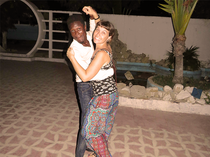 A black man and a white woman locked in a dance pose and smiling at the camera.